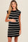 woman wearing a black and white striped knitted maternity dress, gently holding her baby bump