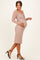 woman wearing a blush lace maternity dress and holding her baby bump