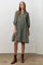 woman wearing an olive green floral button-up dress with puff sleeves and brown ankle boots