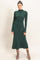 woman wearing a dark green ribbed midi dress with long sleeves and a fitted silhouette, paired with tan ankle boots