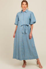 woman wearing a light blue floral button-up maternity dress with a tie belt and puff sleeves