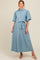 woman wearing a light blue floral button-up maternity dress with a tie belt and puff sleeves