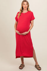 woman wearing a bright red ribbed maternity dress with side slits and holding her baby bump