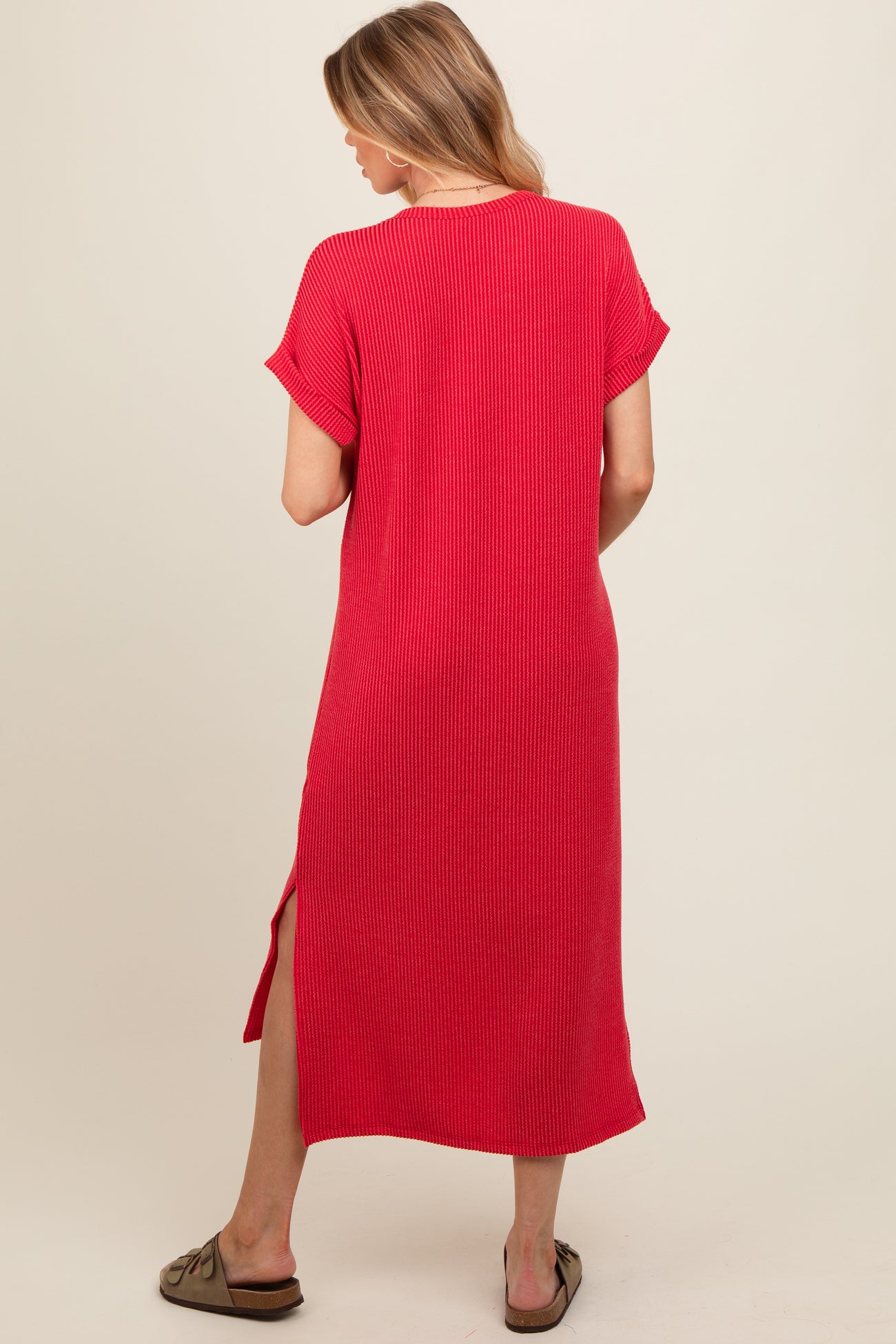 woman wearing a red ribbed maternity maxi dress with short sleeves and side slits