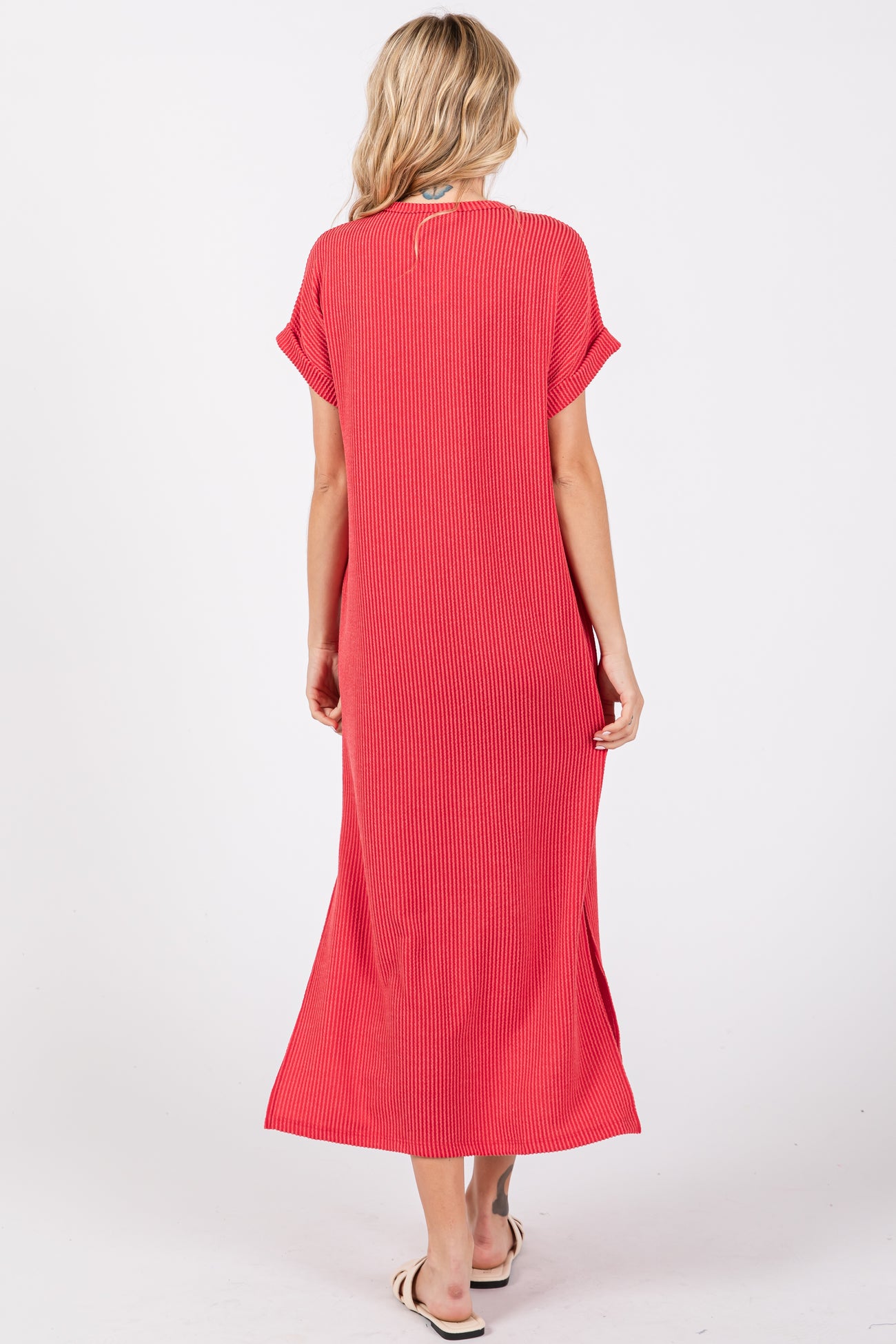 woman wearing a red striped maxi dress with short sleeves and side slits, viewed from the back