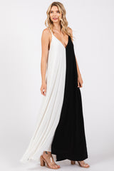woman wearing a black and white color-block sleeveless maxi dress with a plunging neckline and a flowing silhouette