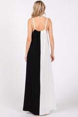 woman wearing a sleeveless black and white color-block maxi dress with a flowy silhouette and back detail