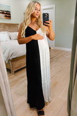 woman wearing a black and white color-block maternity maxi dress and holding her baby bump