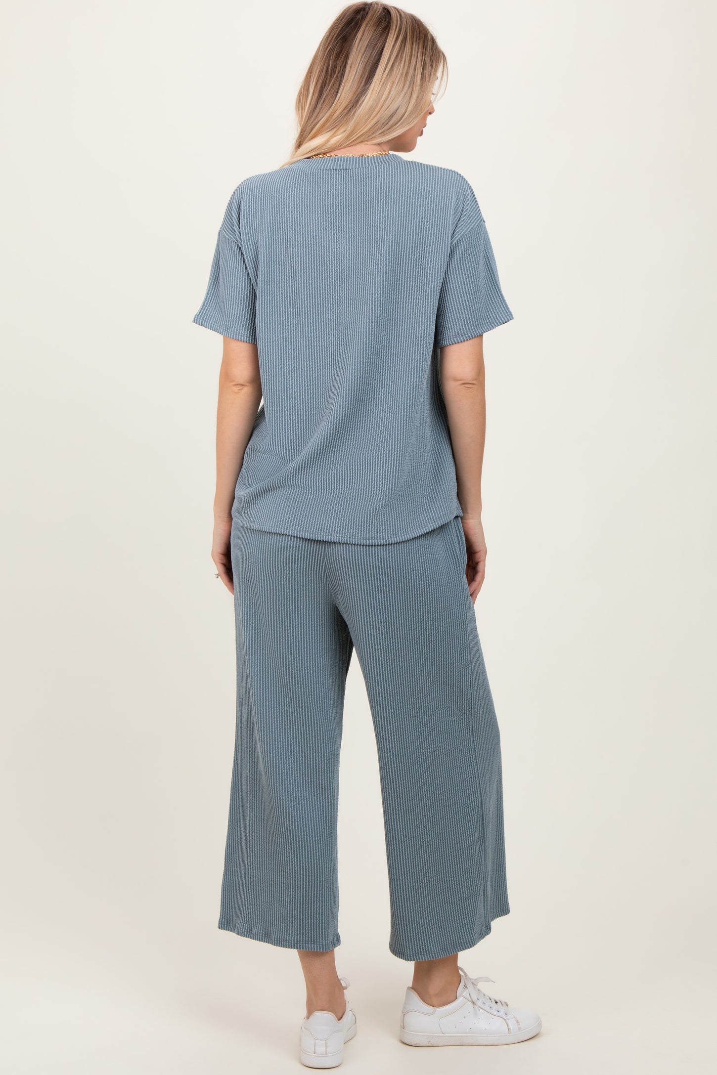woman wearing a light blue ribbed lounge set with a loose t-shirt and wide-leg pants, viewed from the back