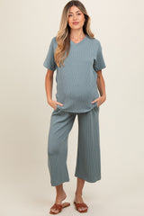 woman wearing a teal maternity loungewear set with short sleeves and wide leg pants, showcasing her baby bump