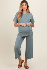 woman wearing a green ribbed maternity set with a V-neck top and cropped wide-leg pants, showing her baby bump