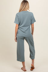woman wearing a green ribbed maternity top and matching cropped pants, showing a relaxed fit from the back