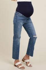 woman wearing distressed light blue maternity jeans with a navy blue over-the-bump panel and a visible baby bump