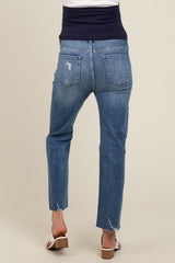 woman wearing light blue distressed maternity jeans with a straight leg and a frayed hem, seen from the back