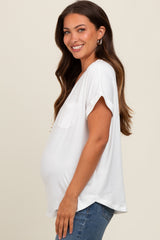 woman wearing a white short sleeve maternity top with a side pocket and a visible baby bump