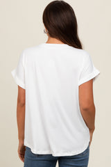 woman wearing a white short sleeve maternity top, showing the back view with rolled sleeves and a relaxed fit
