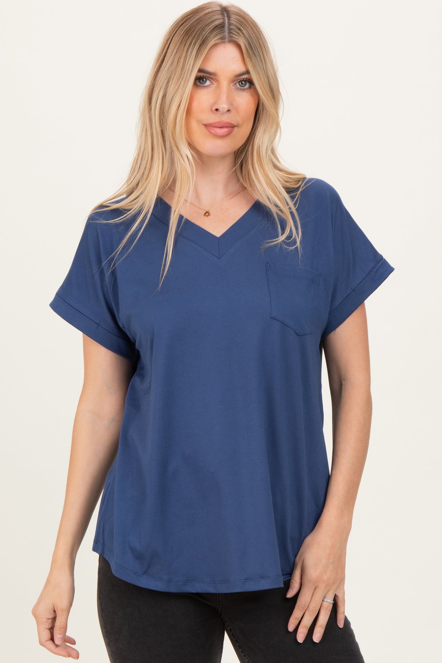 woman wearing a navy blue v-neck short sleeve top with a chest pocket