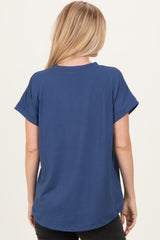 woman wearing a blue short sleeve top with rolled cuffs, shown from the back