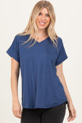 woman wearing a navy blue short sleeve v-neck top with a front pocket and rolled sleeves