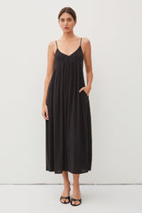 woman wearing a black sleeveless maxi dress with pockets and a flowy silhouette