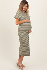woman wearing a green and white striped maternity dress, gently holding her baby bump