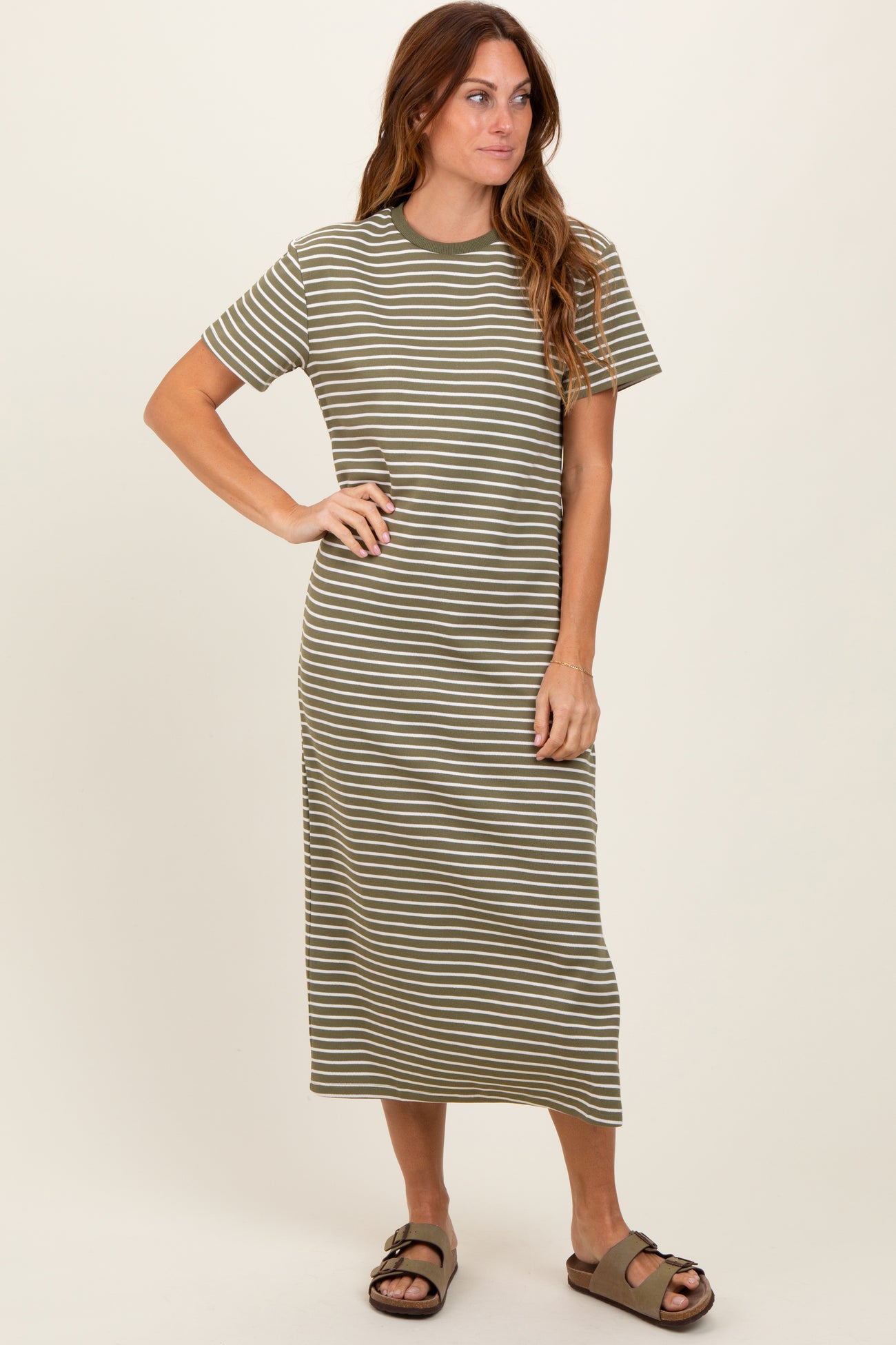 woman wearing a green and white striped short sleeve midi dress with a relaxed fit