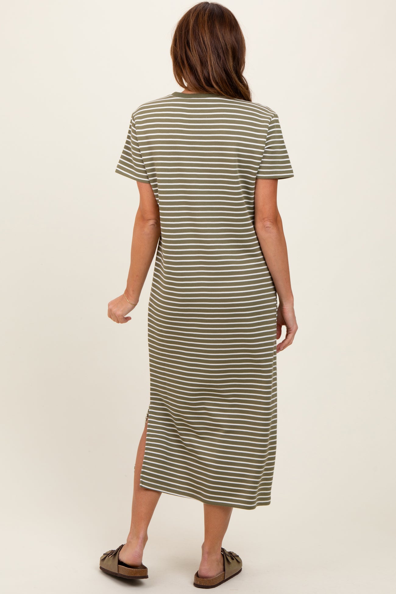 woman wearing an olive green and white striped short sleeve maxi dress with side slits