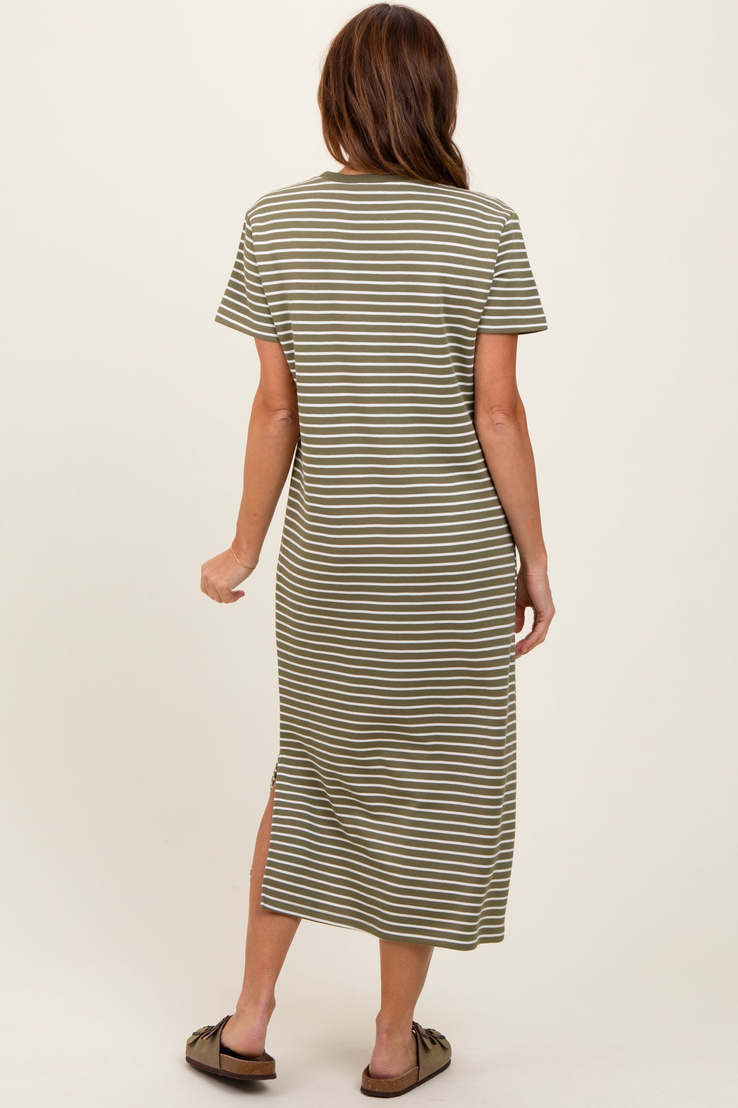 woman wearing an olive green and white striped short sleeve maxi dress with side slits