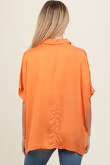 woman wearing an orange maternity top with a loose fit and short sleeves, viewed from the back