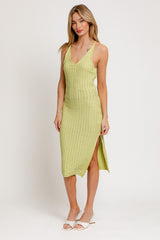 woman wearing a light green knitted midi dress with side slit and thin straps