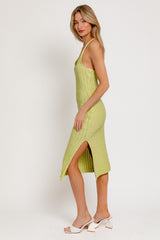 woman wearing a light green knitted midi dress with side slits and spaghetti straps
