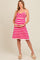woman wearing a pink and white striped maternity dress with spaghetti straps and holding her baby bump