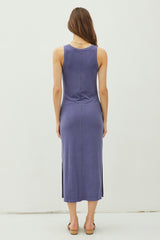 woman wearing a purple sleeveless midi dress with a side slit, viewed from the back