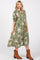 woman wearing a green patterned midi dress with puff sleeves and brown ankle boots