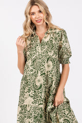 woman wearing a green and beige floral print dress with short sleeves and a collared neck