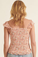woman wearing a pink and multicolor smocked top with frilled sleeves, shown from the back