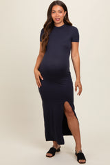 woman wearing a navy blue short sleeve maternity dress with a side slit and a visible baby bump