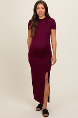 woman wearing a burgundy short sleeve maternity maxi dress with a side slit and showing her baby bump