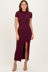 woman wearing a burgundy short sleeve maxi dress with a side slit and standing against a neutral background