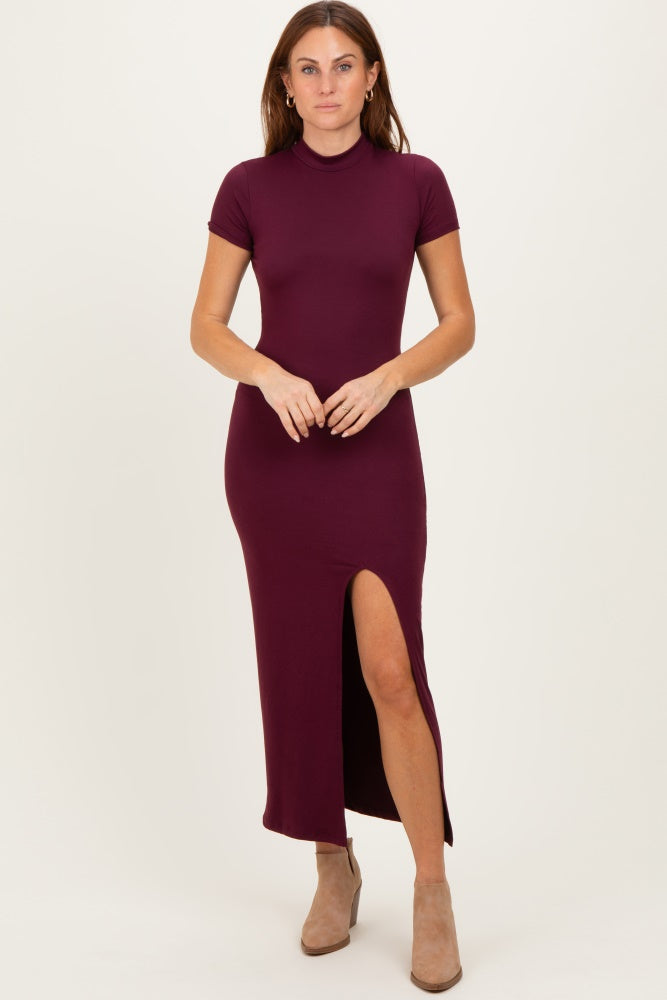 woman wearing a burgundy short sleeve maxi dress with a side slit and fitted silhouette