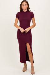 woman wearing a burgundy short sleeve maxi dress with a side slit and fitted silhouette