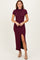 woman wearing a burgundy short sleeve maxi dress with a side slit and fitted silhouette