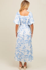 woman wearing a blue and white floral print maxi dress with puff sleeves and a smocked back