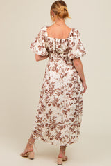 woman wearing a floral print maternity maxi dress with puff sleeves and gathered back details
