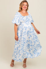 woman wearing a white floral maternity dress with short puff sleeves and a cinched waist, showing her baby bump