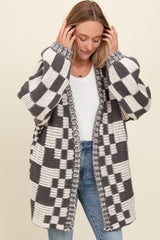 woman wearing a gray and white checkered oversized knitted cardigan over a white t-shirt and blue jeans