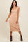 woman wearing a beige ribbed knit crop top and matching midi skirt with fitted silhouette and brown ankle boots