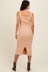 woman wearing a fitted light pink ribbed midi dress with a side slit and a scoop neckline