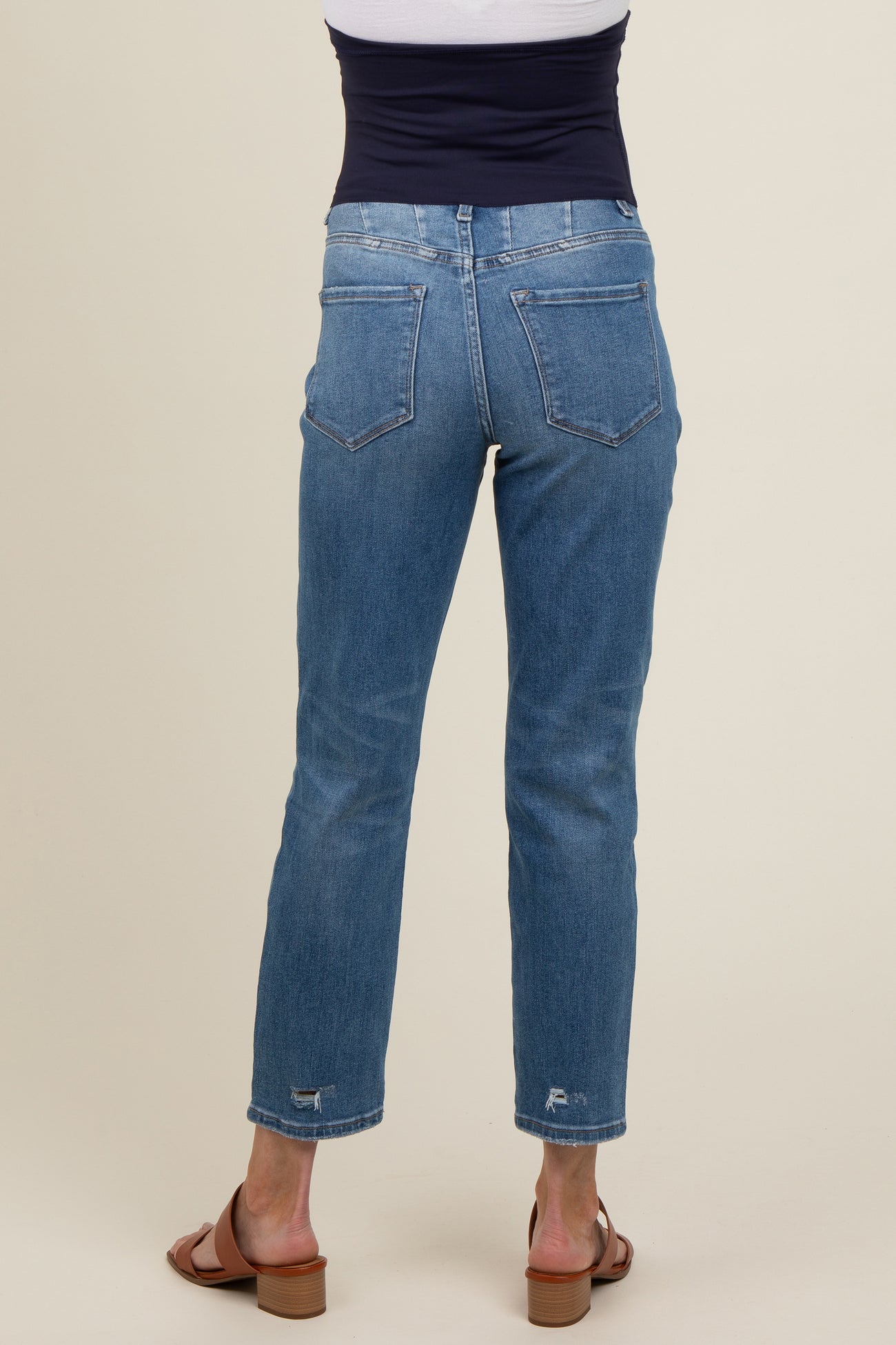 woman wearing light blue maternity jeans with a straight leg cut, viewed from the back, showing a casual style