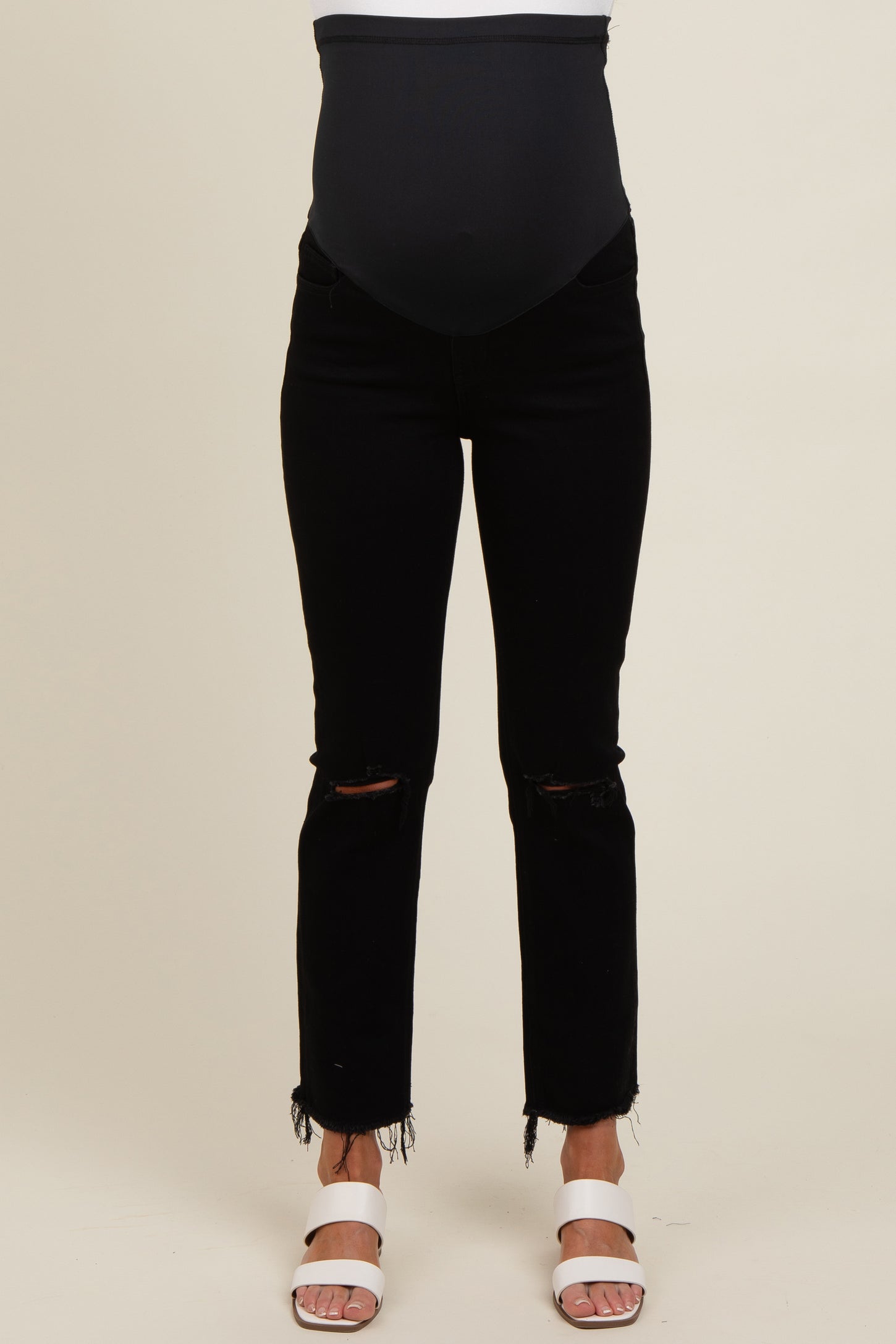 woman wearing black maternity jeans with a belly support band and distressed hem